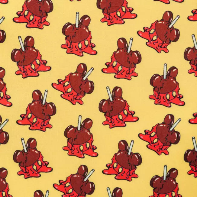 Pattern of MIckey Mouse shaped candy apples on a yellow background