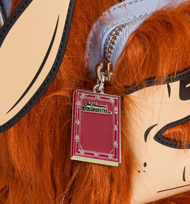 Close-up of Ludo with orange hair and a red book charm
