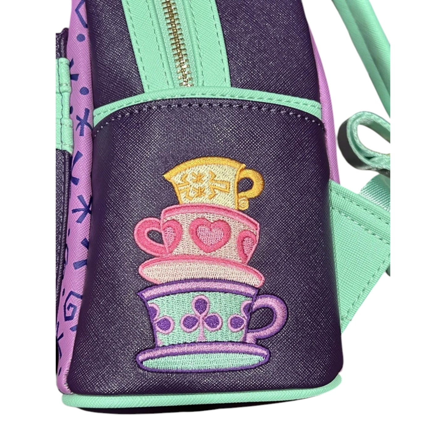 Mini backpack with embroidered teacup design on a white background