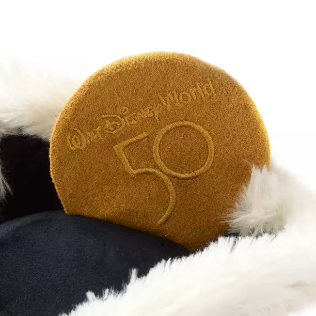 Round brown pillow with 'Walt Disney World 50' text on a black and white fur background
