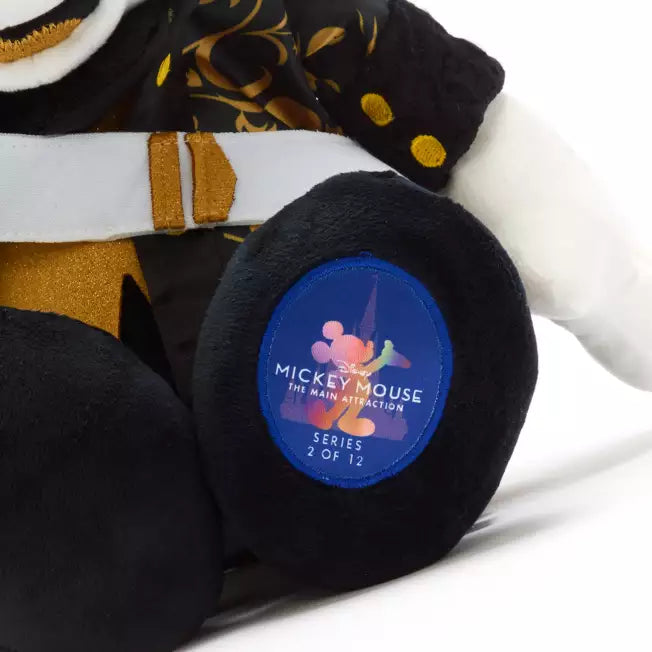 Plush toy with a blue patch featuring Mickey Mouse branding on a white background