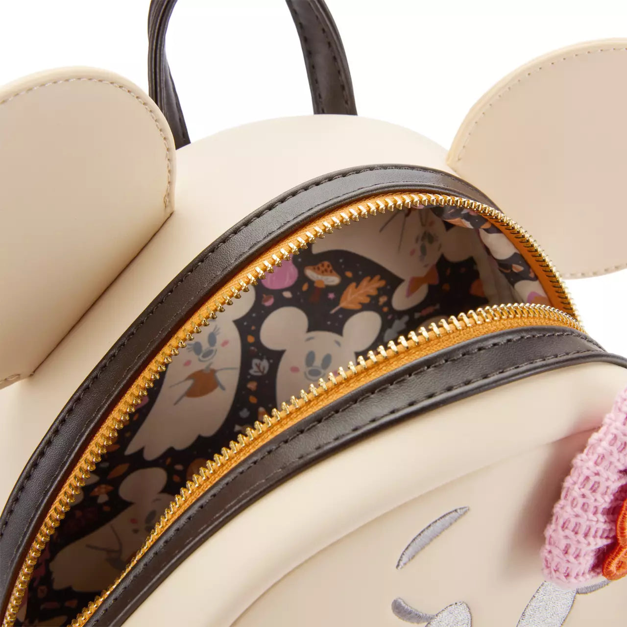 Close-up of the inside of the mini backpack with a zipper, showing a patterned interior.