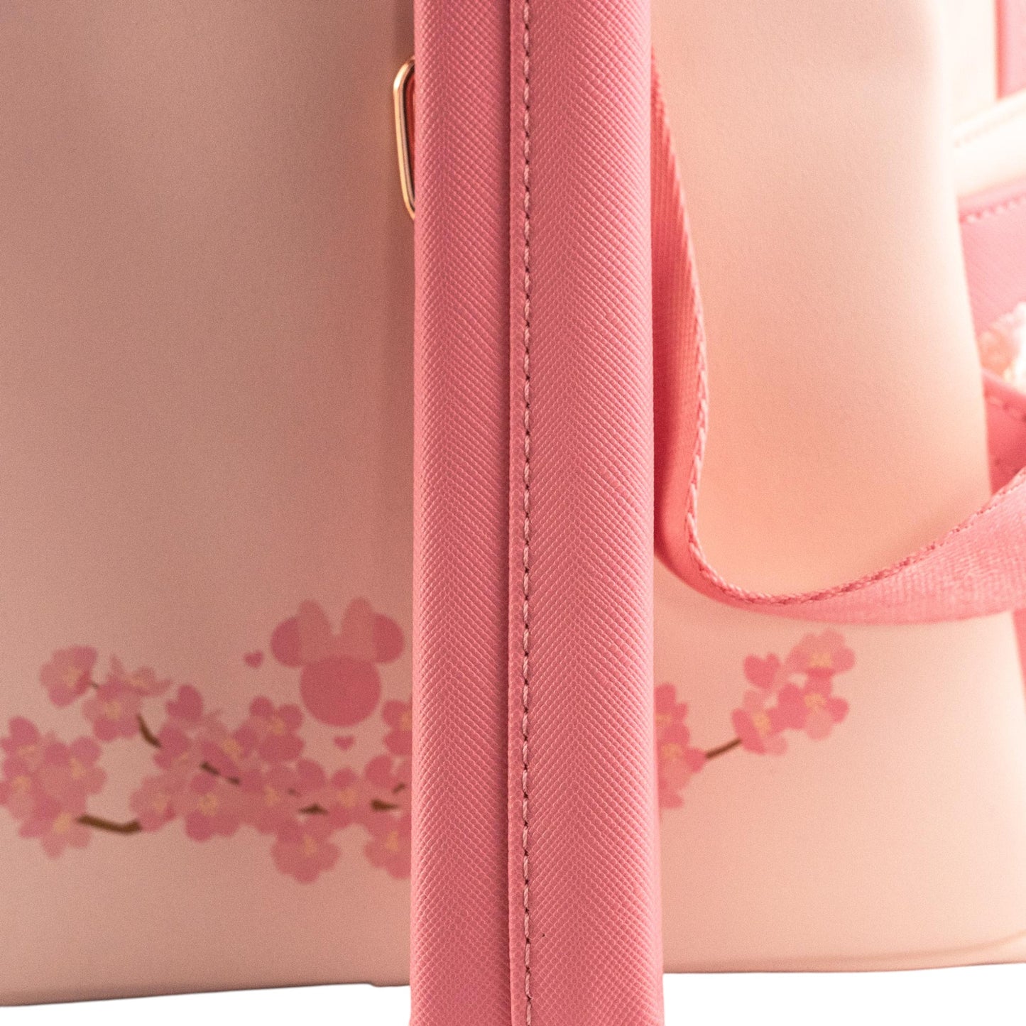 Pink handbag with cherry blossom design on a light pink background