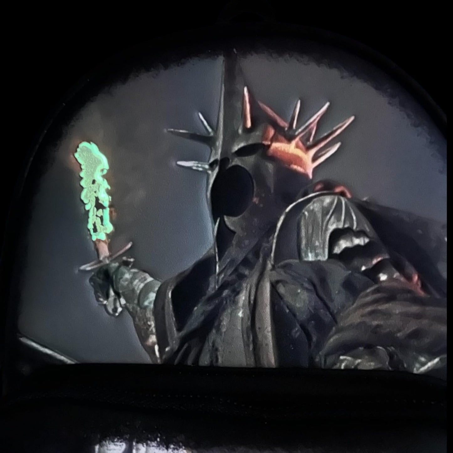 Nazgul glowing with a fiery sword with a green light effect on a dark background