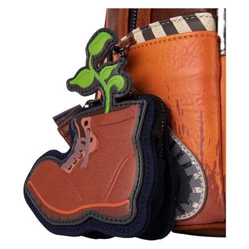 Keychain in the shape of a boot with a plant design on a brown leather bag.