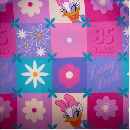 Fabric with Daisy Duck designs and floral patterns on a checkered background.
