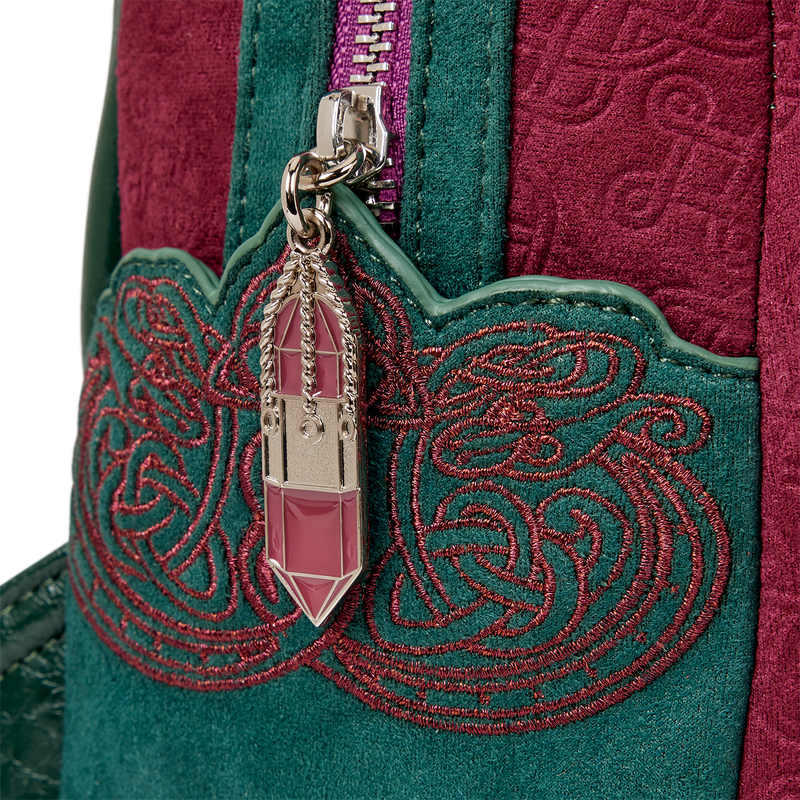 Close-up of a green and red embroidered bag with a crystal charm.