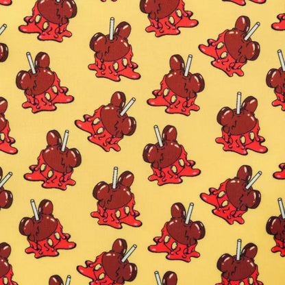 Pattern of MIckey Mouse shaped candy apples on a yellow background