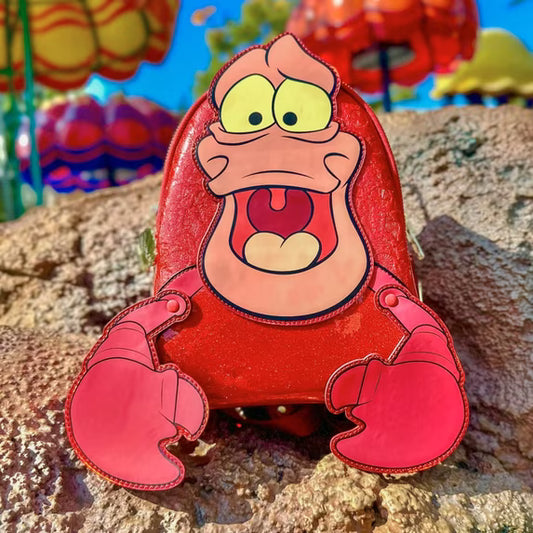 Sebastian, from The Little Mermaid, with a surprised expression and figural claws on a rocky surface