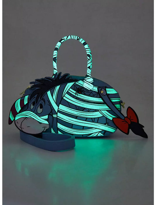 Glowing Mummy Eeyore crossbody bag on a dark background
