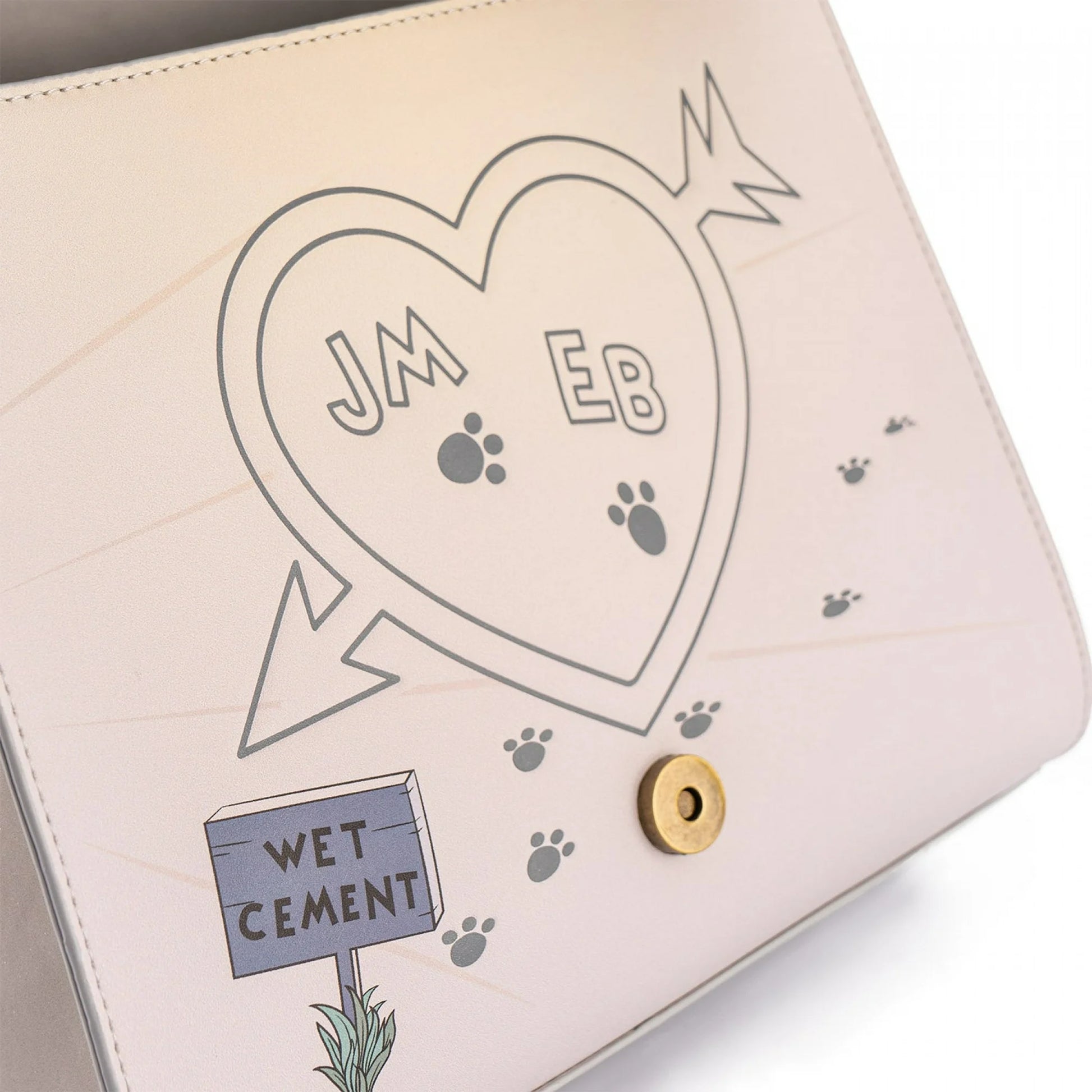 Bag with heart design, initials, paw prints, and 'Wet Cement' sign.