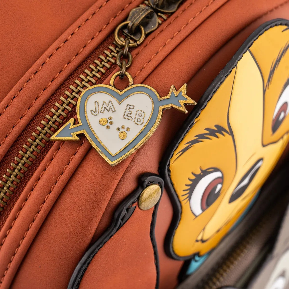 Close-up of a brown bag with a heart-shaped charm with Lady and Tramp's initials