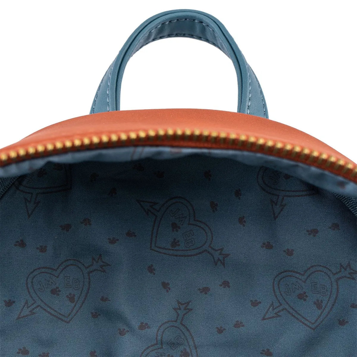 Close-up of a blue bag with gold zipper and heart pattern interior.