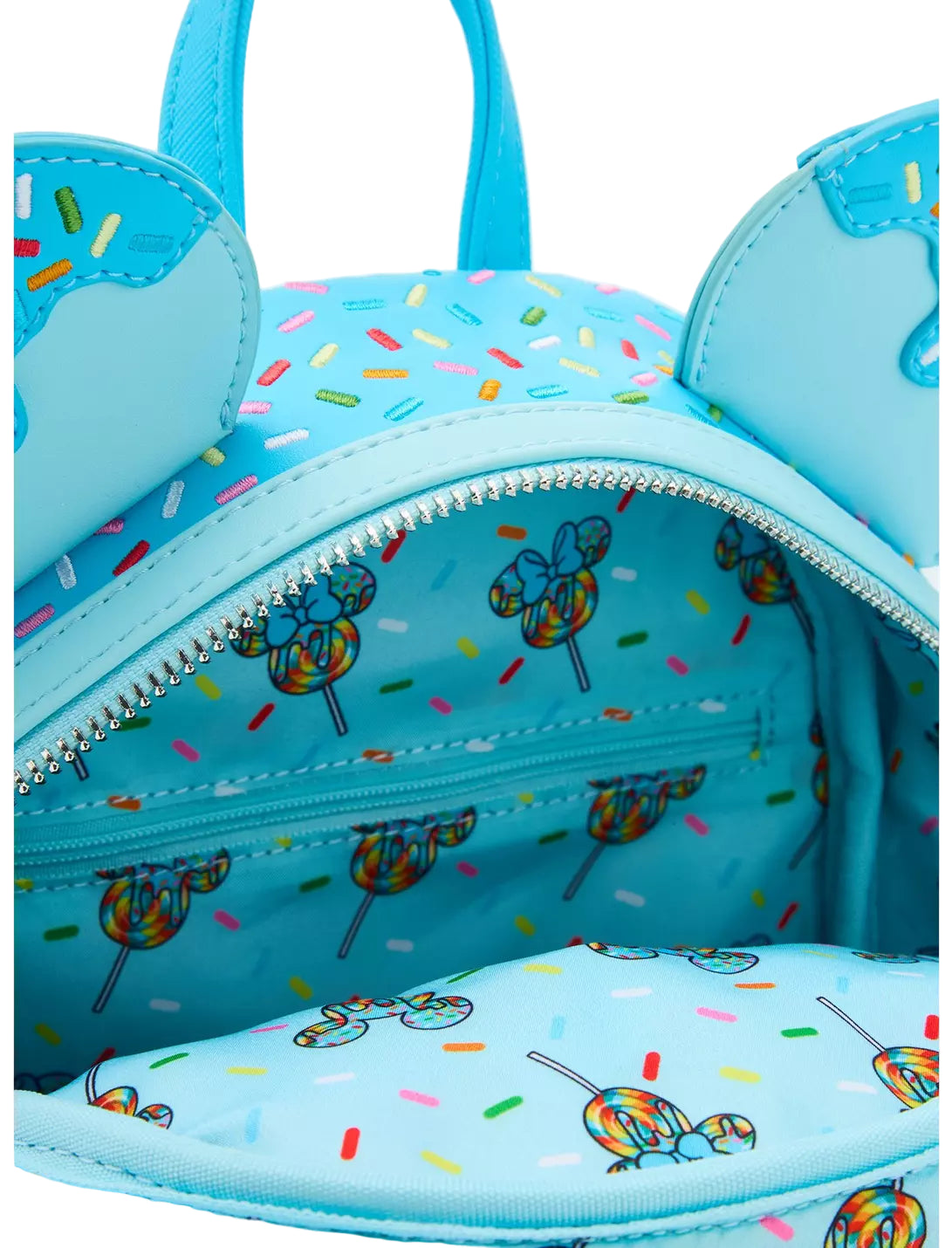 Inside Minnie Mouse Lollipop Blue Sprinkle Ears Backpack with character ears and lollipop design with lollipop themed design on a white background