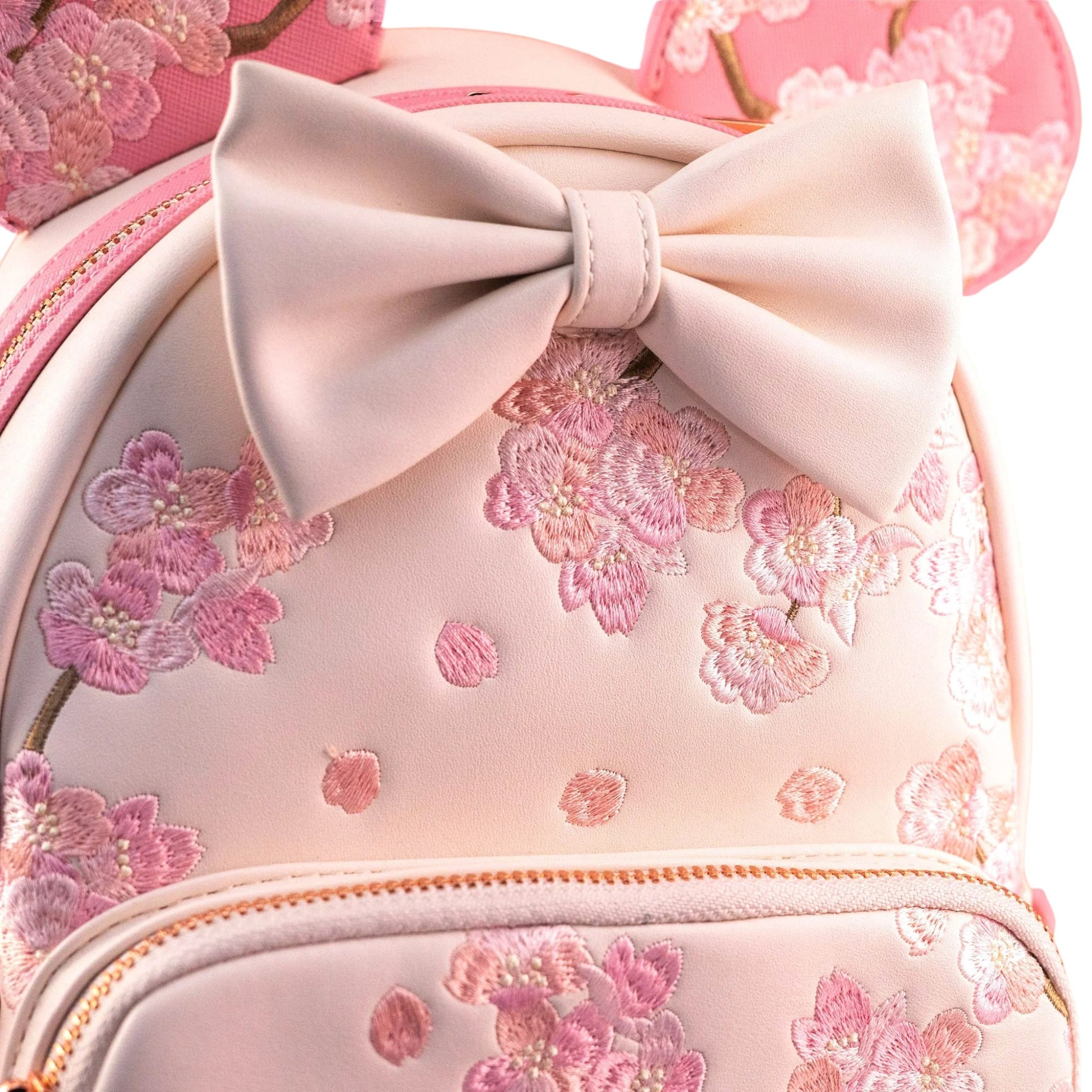Pink backpack with floral embroidery and a large bow on a white background