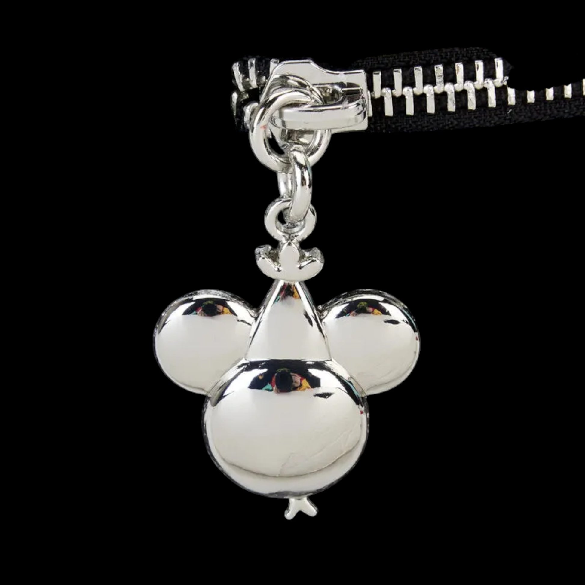 Silver mickey head zipper charm on a black background