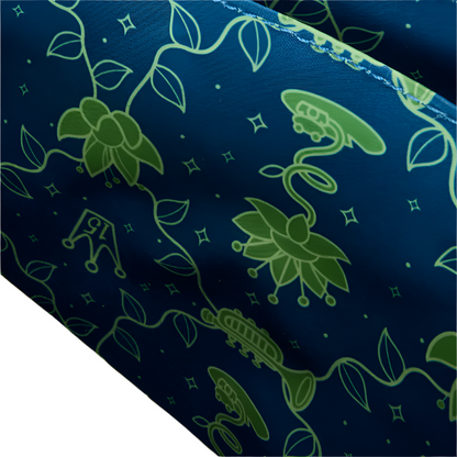 Close-up of inside view of Princess and the Frog Crossbody bag with green floral pattern on blue fabric on a white background.