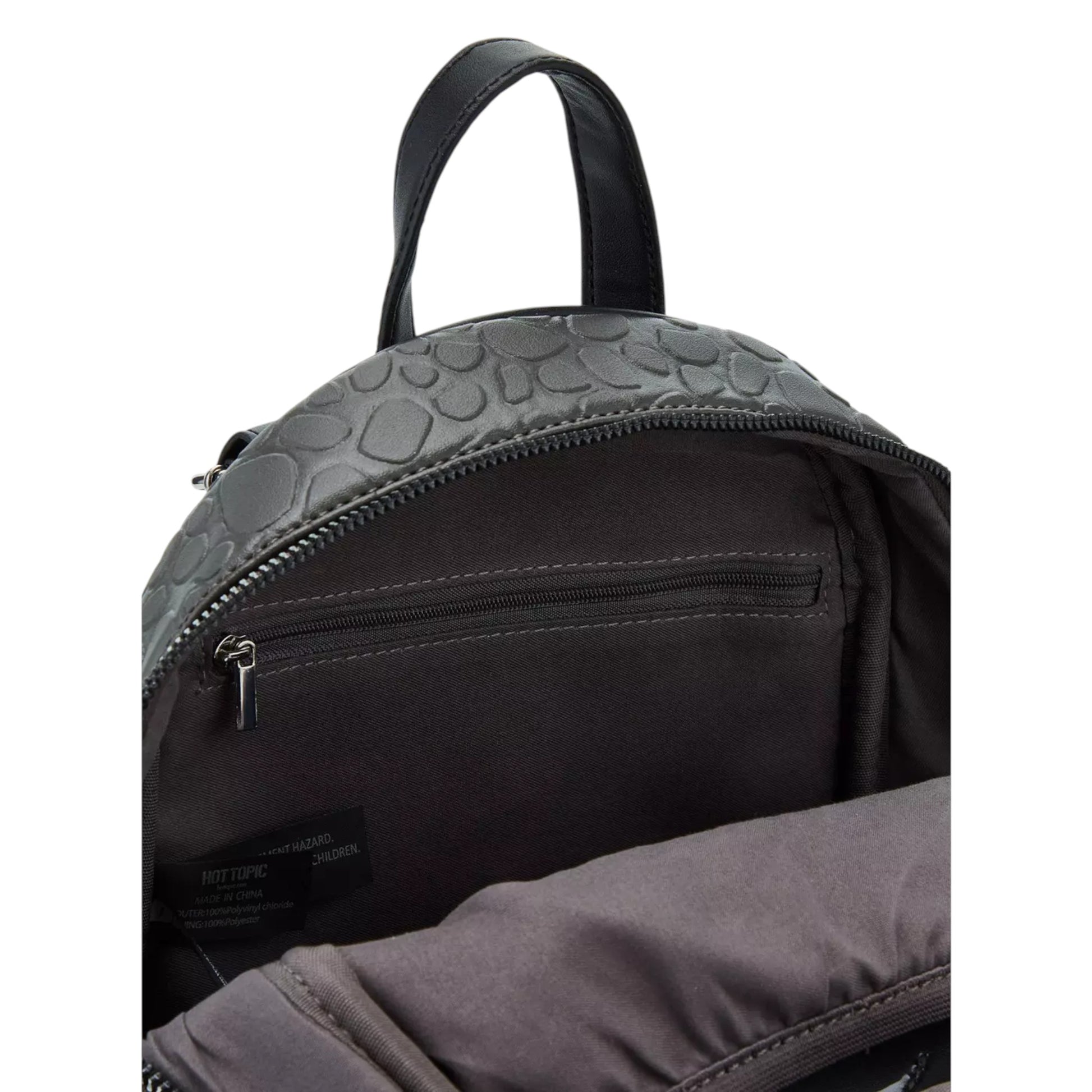 Close-up of a black backpack with textured top panel on a white background