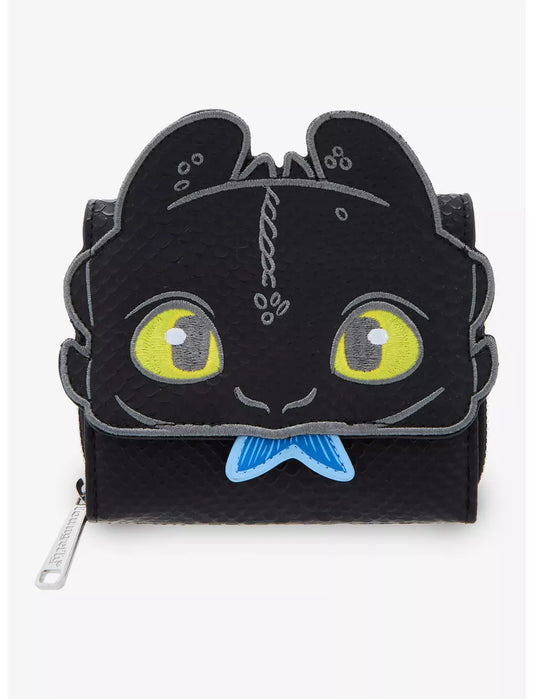 Front view Toothless Figural Wallet with yellow eyes holding a fish in his mouth on a white background