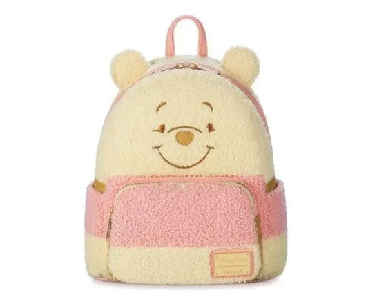 Plush backpack shaped like Winnie the Pooh with pink and beige colors on a white background